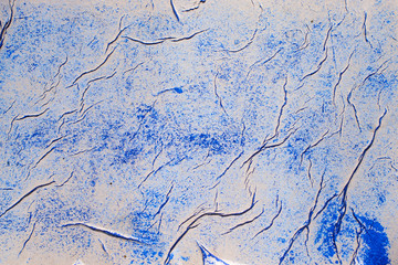 Naklejka premium A sheet of crumpled paper smeared with blue paint. Abstract background for designers.