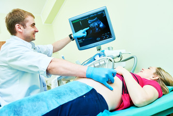 Ultrasound test. Pregnancy. Gynecologist checking fetal life with scanner.