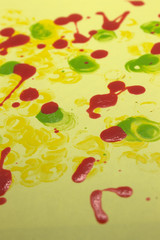 This is a photograph of Red,Green and Yellow nail polish splattered onto a Yellow paper