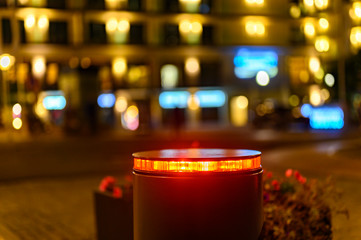 A retractable bollard with a red warning light as a barrier to a pedestrian area at night in...