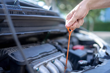 Man checking the oil level in car engine, Check and maintenance the oil level in car with yourself.