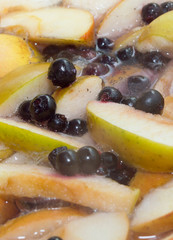 Apples and black currant berries in compote, cooking process