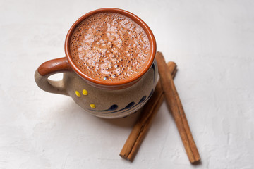 Mexican hot chocolate with cinnamon stick on white background