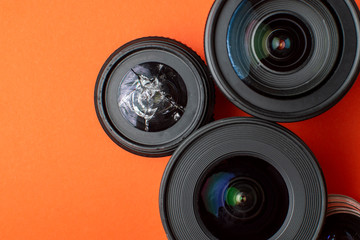 Fototapeta broken modern photo lens on a colored background, photographic equipment repair concept obraz