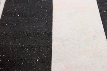 This is a photograph of a shiny textured Black and White striped background created using acrylic paint and sprinkled with pastel colored pigments