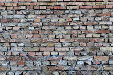 Brick wall and barbed wire. Background horizontal image, place for text.