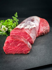 Dry aged beef fillet steak natural with a bouquet garni as closeup on black background with copy...