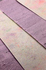 This is a photograph of a shiny textured Purple and White striped background created using acrylic paint and sprinkled with pastel colored pigments