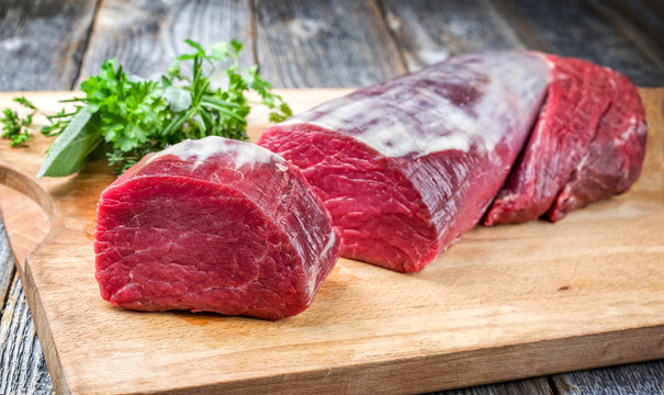 Dry aged beef fillet steak natural offered as closeup on a wooden cutting board
