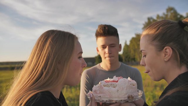 Girls funny beat their friend with a cake in the face.