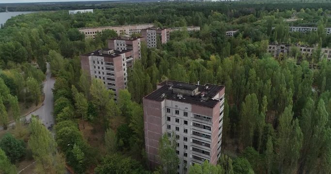 Flying a drone over Pripyat between houses overlooking the sarcophagus of the 4th power unit
