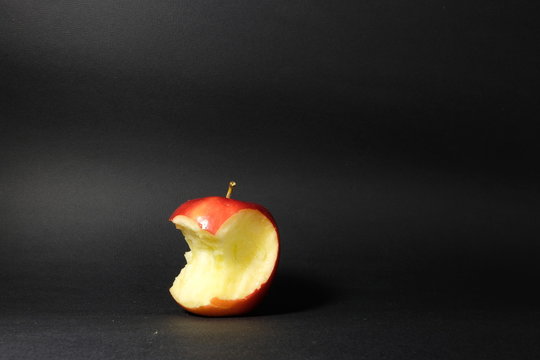 angebissener Apfel vor schwarzem Hintergrund