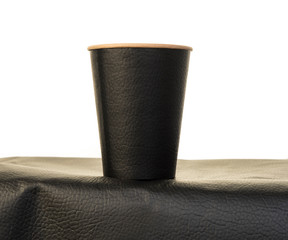  Black paper cup on a black table isolated on white background