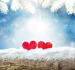 Winter snow bright background. Holiday landscape with wood, heart and pine branches in the frost.