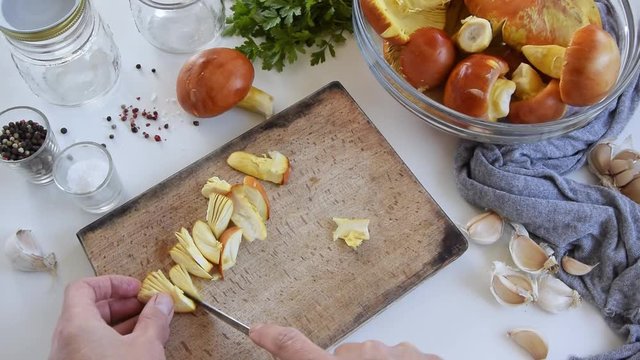 Personal perspective of woman hands cooking Amanita caesarea (known as Caesar's mushroom)