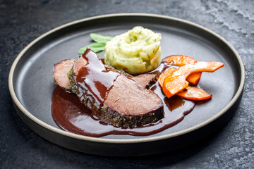 Traditional roasted beef heart with fried pumpkin slices and mashed potatoes in gravy red wine...