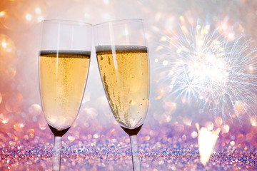 New Years eve concept with bokeh, fireworks and glasses of champagne. 