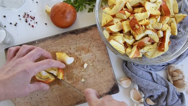 Personal perspective of woman hands cooking Amanita caesarea (known as Caesar's mushroom)