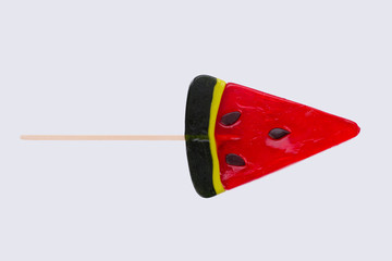 Lollipop in a shape of watermelon. Sweet candy in a shape of fruit with stick. Sweet dessert on white background.