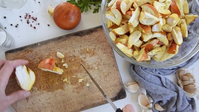 Personal perspective of woman hands cooking Amanita caesarea (known as Caesar's mushroom)