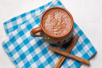 Mexican hot chocolate with cinnamon stick on white background