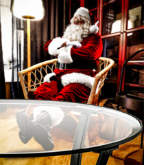 Santa Claus resting in a living room after delivering prtesents. Comfortable and cozy place in home interior.