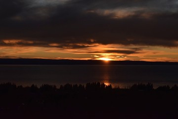 Cold sunrise on the lake, golden sky with clouds
