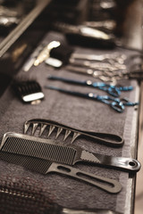 Barber tool in barbershop. Hairdresser tool. Scissors, combs, razors, clippers. Tool for the wizard. Organization of the workplace. Selective focus.