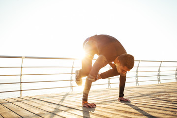 young man doing a bakasana, crane pose during an intense yoga practice