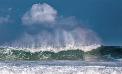 Obraz premium Seascape. Powerful ocean wave on the surface of the ocean. Wave breaks on a shallow bank. Stormy weather, stormy clouds sky background.