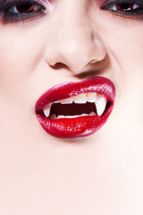 Obraz premium Sexy vampire. Women's lips with red lipstick. Screaming mouth with vampire fangs,