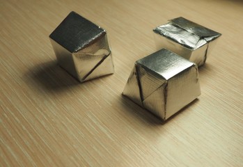 Photo of  sweets in a silver wrapper on a light wood background