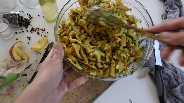 Personal perspective of woman hands cooking Amanita caesarea (known as Caesar's mushroom)