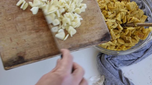 Personal perspective of woman hands cooking Amanita caesarea (known as Caesar's mushroom)