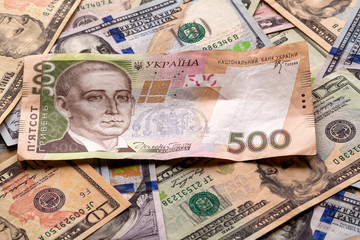 Money and finances concept. Ukrainian national currency bill worth five hundred grivna on colorful abstract background of American dollar different banknotes.