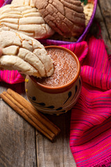 Fototapeta na wymiar Mexican hot chocolate with sweet conchas bread on wooden background