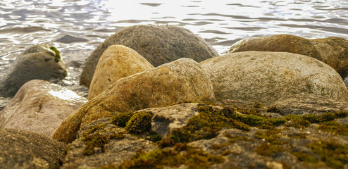 Stones by the water. Stones on the shore.