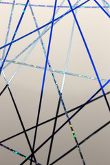 This is a photograph of a geometric design created using dark and light Blue tape applied onto a White paper