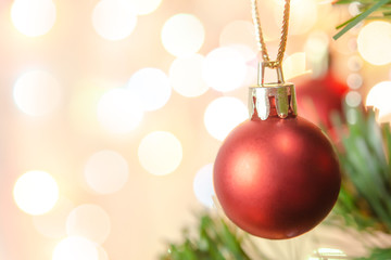 Christmas decoration. Hanging red balls on pine branches Christmas tree garland and ornaments over abstract bokeh background with copy space.