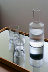 Two glasses and carafe with water on a modern tray, still life, indoors