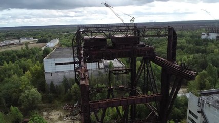 Rusty giant crane loading reactors of the 5th and 6th Chernobyl power units in the Chernobyl exclusion zone, Ukraine. Aerial photography with drone