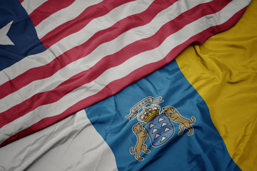 waving colorful flag of canary islands and national flag of liberia.