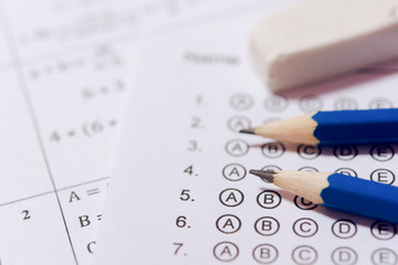 Pencil and eraser on answer sheets or Standardized test form with answers bubbled. multiple choice answer sheet © Achira22