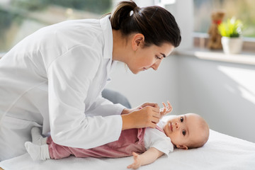 medicine, healthcare and pediatrics concept - female pediatrician doctor with baby girl patient at...