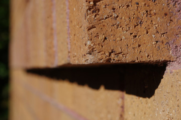 Brown brick at the end of an exterior window sill 