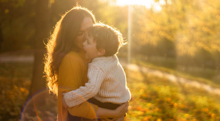 Mother and son walking in the Park and enjoying the beautiful autumn nature