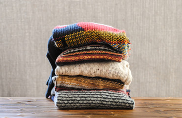 Stack of winter sweaters on a blurred background. Winter style. Warm concept.