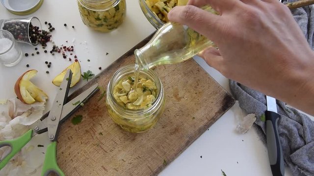 Personal perspective of woman hands preparing Amanita caesarea (known as Caesar's mushroom). Put the mushrooms in jars in oil