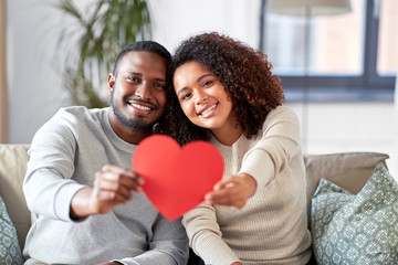 love, valentines day and relationships concept - happy african american couple holding red heart...