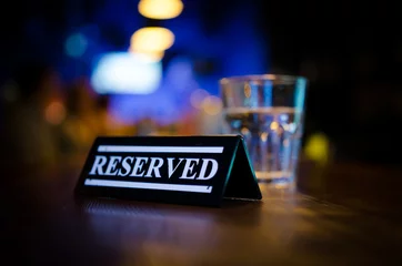 Foto op Plexiglas Plastic reserved plate on an arranged restaurant table © anniebrusnika